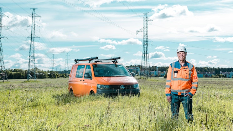 mies seisoo pakettiauton vieressä pellolla