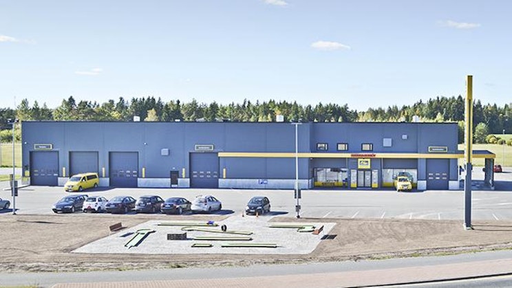 sininen rakennus, jonka eteen on pysäköity autoja