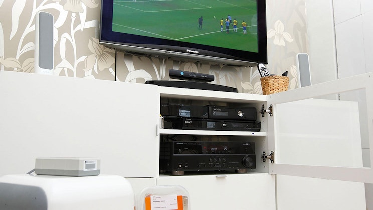 taulutelevisio, joka on valkoisen kaapin päällä