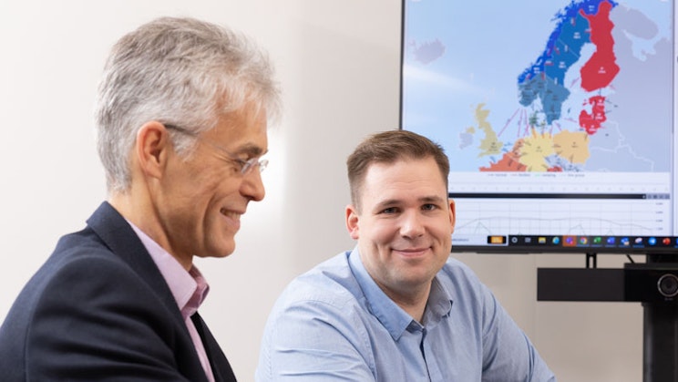 kaksi miestä on pöydän ääressä tietokoneen näytön edessä