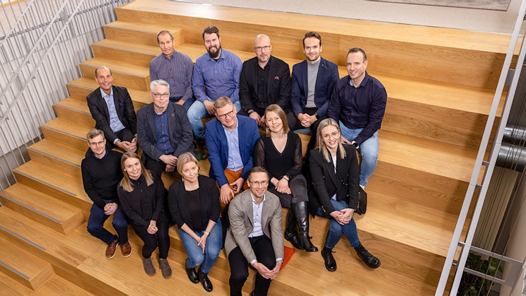 ryhmä ihmisiä istumassa puisten portaiden päällä