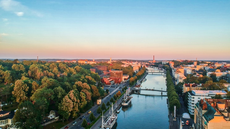 en flod som rinner genom en stad bredvid höga byggnader