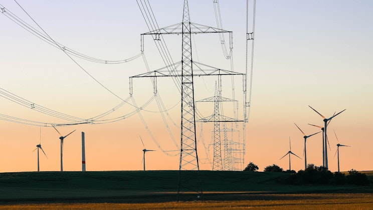 kenttä, jossa on tuulivoimaloita ja voimalinjoja