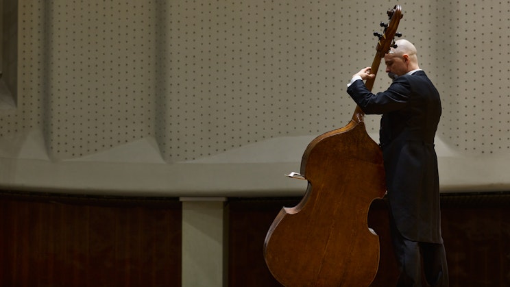 Kuvassa mies soittaa lavalla selloa