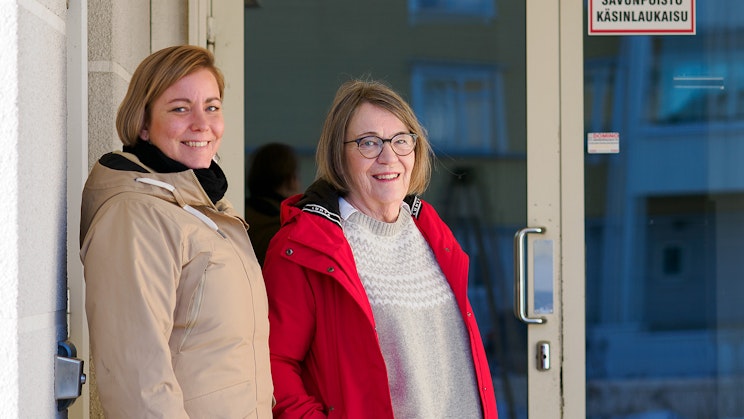 Kuvassa kaksi henkilöä seisoo oven edustalla