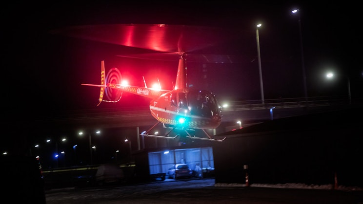 Kuvassa helikopteri laskeutuu illalla