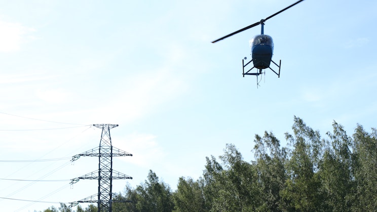 Kuvassa näkyy sähköverkot ja helikopteri