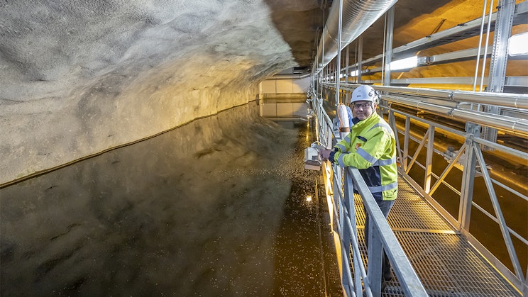 Mies seisoo Kakolan luolassa työvaatteet päällä