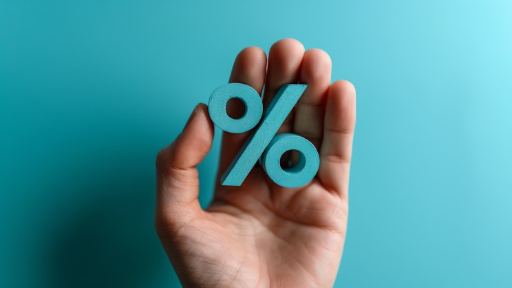 Kämmenellä turkoosin värinen prosenttiluku turkoosilla taustavärillä