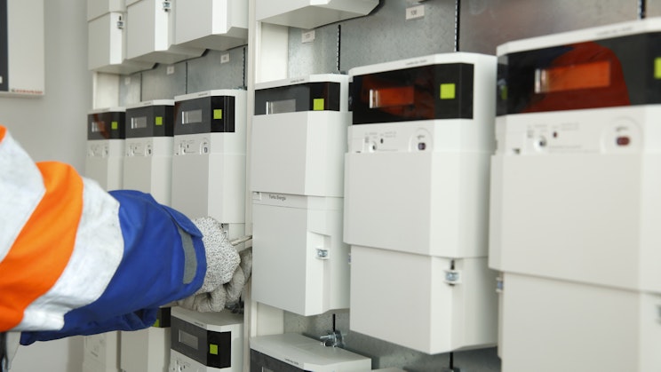 Rivissä sähkömittareita, joita asentaja on asentamassa teknisessä tilassa