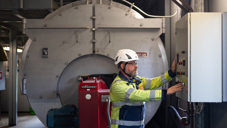 Kuvassa Kari Kartimo seisoo kaukolämmön valvomossa.