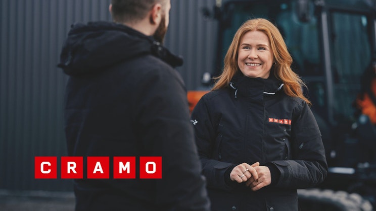 Punatukkainen naisoletettu hymyilee Cramon työtakki päällään