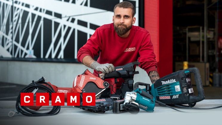 Cramon työntekijä esittelee rakennuskoneita ja sähkötyökaluja.