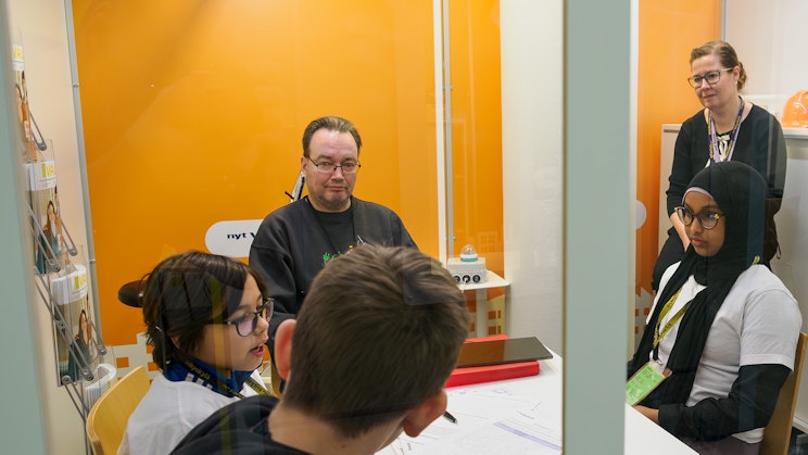 Nuorten yrittäjyys ja talous NYT -yhdistyksen Yrityskylässä nuoria pöydän ääressä.