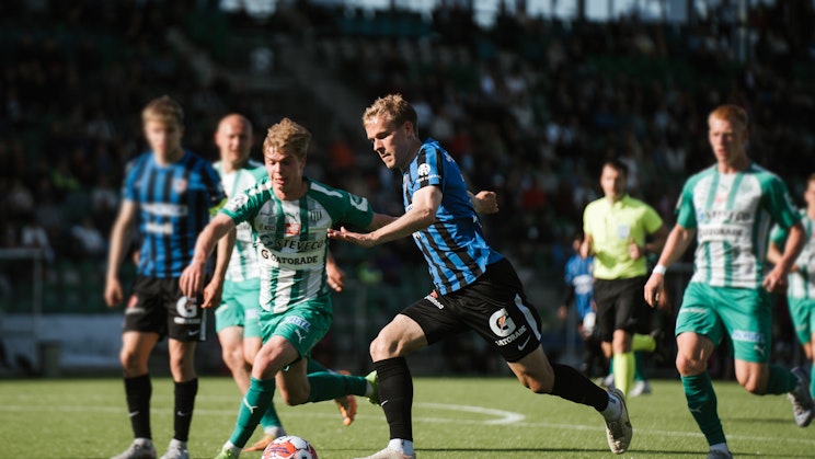Kaksi miesoletettua pelaamassa jalkapalloa