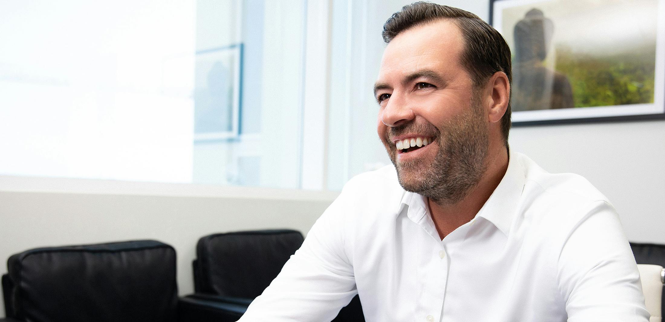 Man in a white shirt smiling