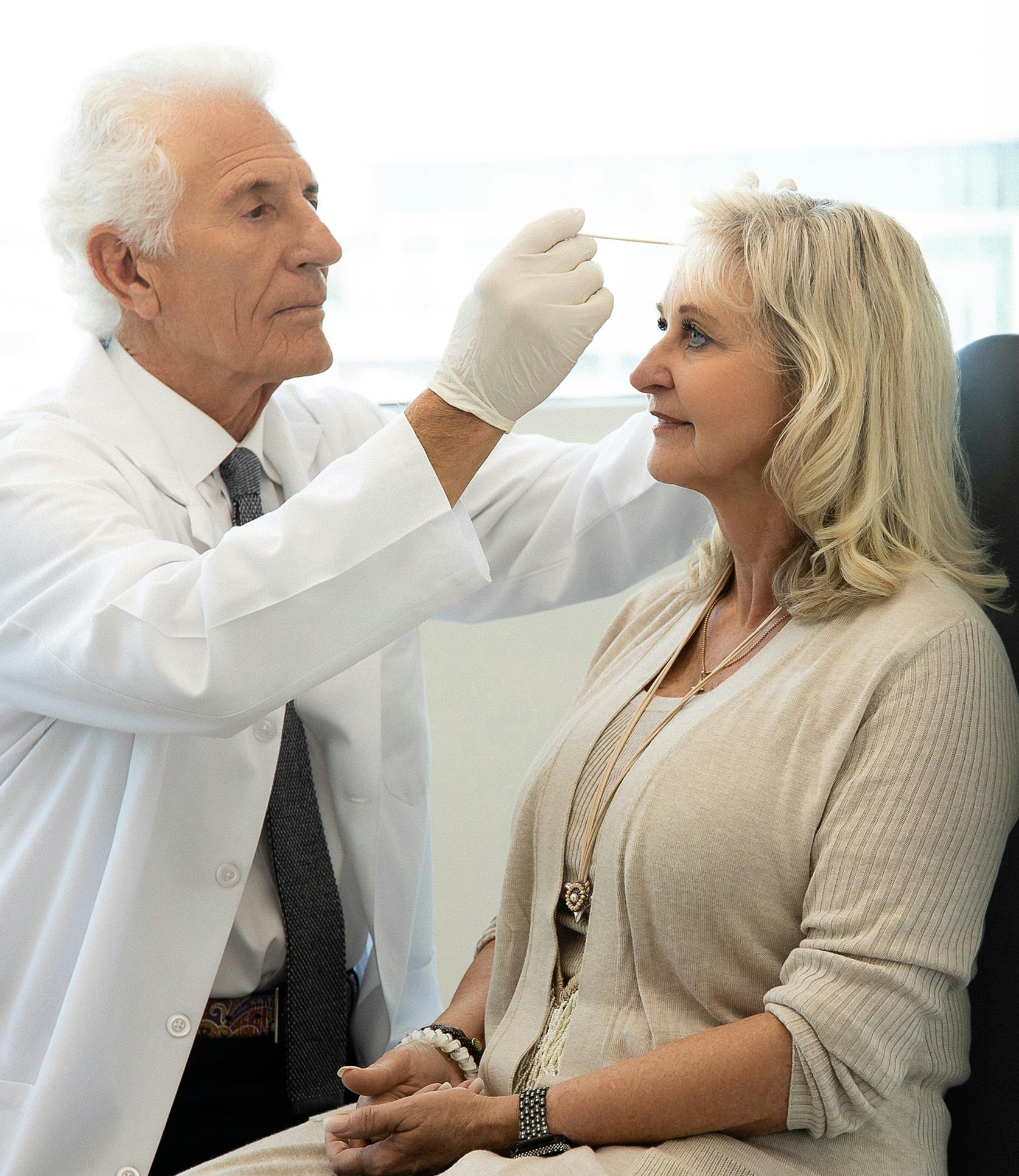 Dr. looking at woman's hairline