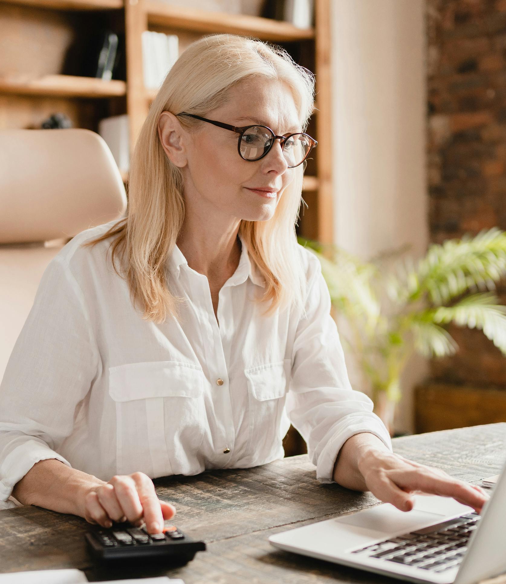 woman looking at laptop with glasses on