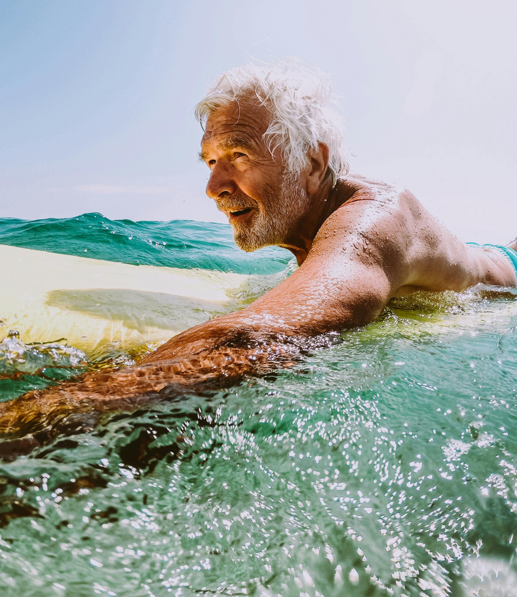 older man surfing in the ocean