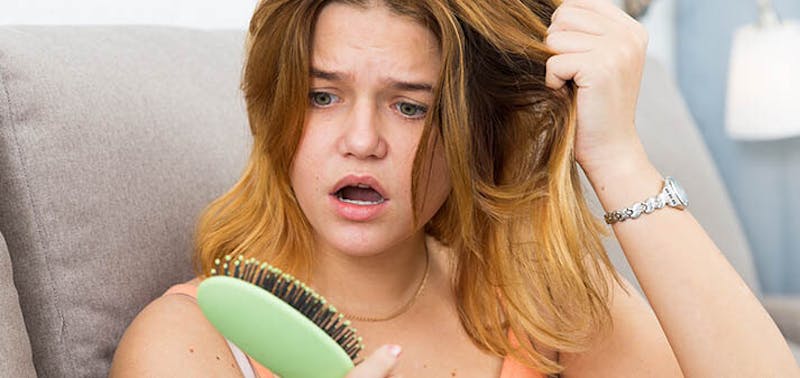 woman looking at a hair brush
