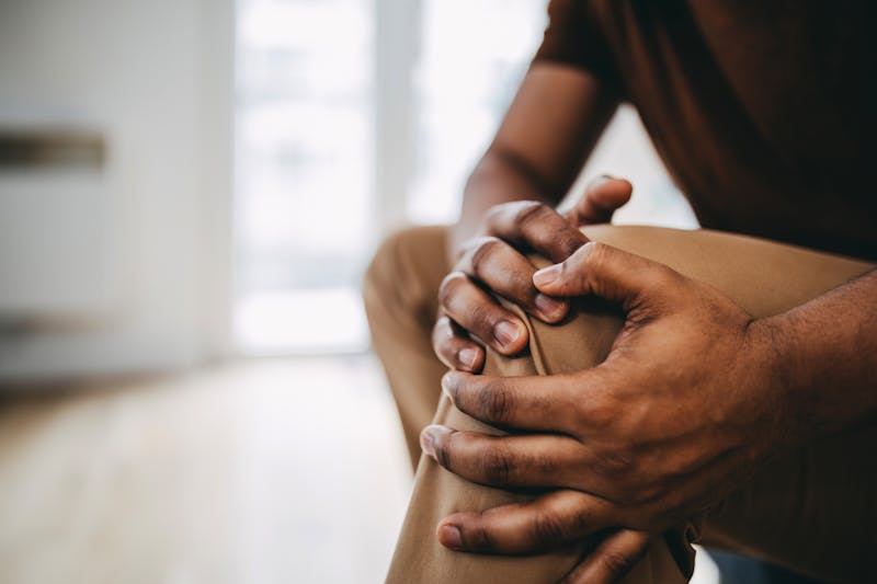 Person holding their knee in pain