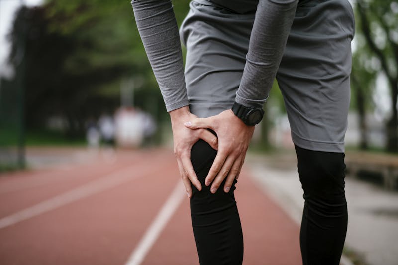 person holding their knee in discomfort