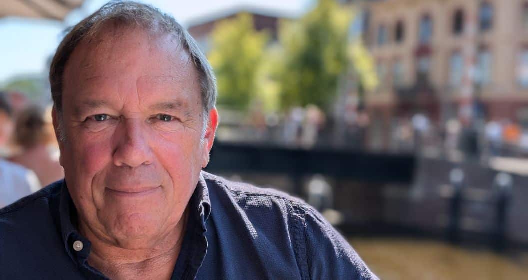 Ad Westerhof with a blue shirt and a Dutch city background