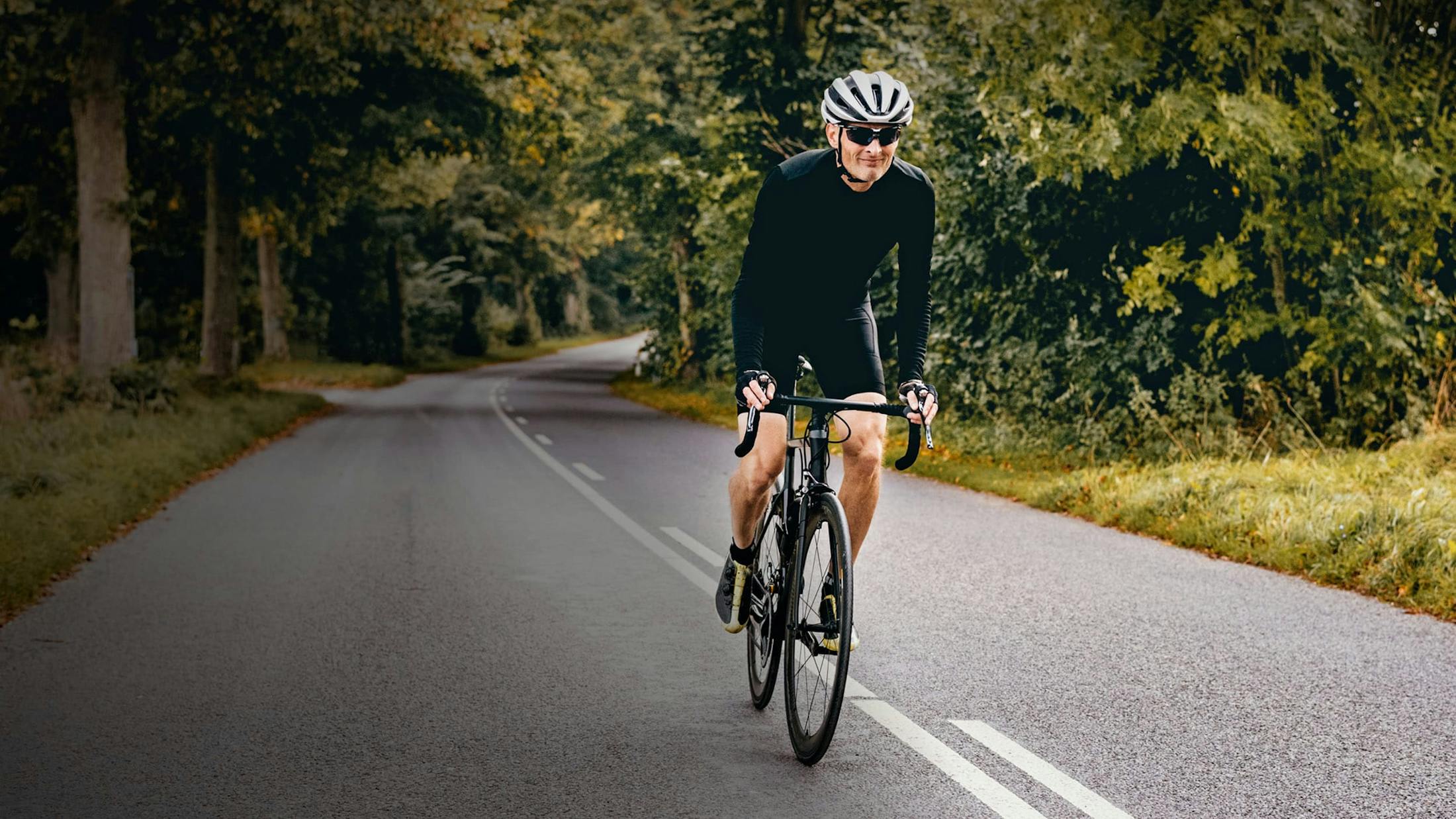 Older man on bike traveling through the forest.