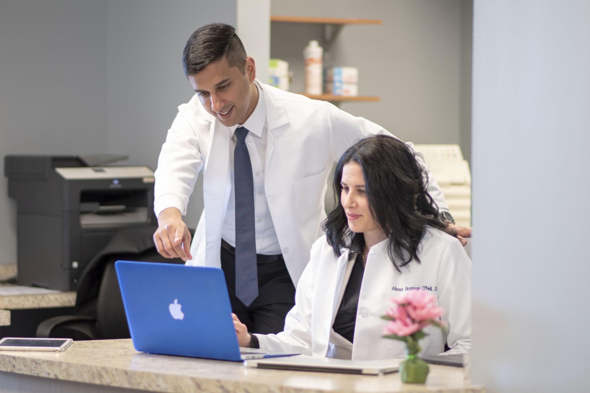 Doctors looking at laptop