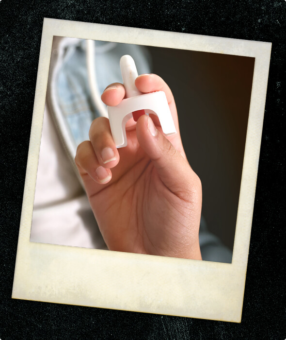 A closeup of someone holding a Naloxone applicator.