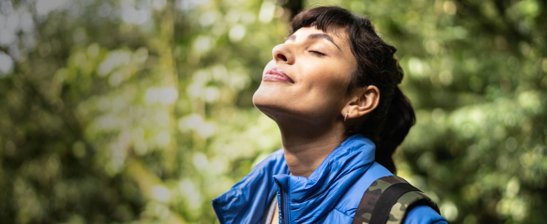 Woman smelling the air in the woods.