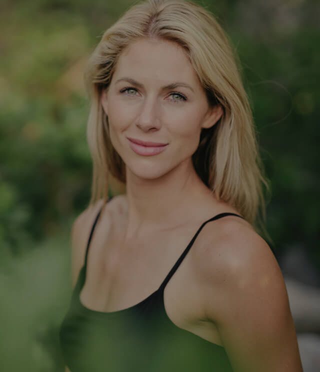 Smiling woman posing outside.