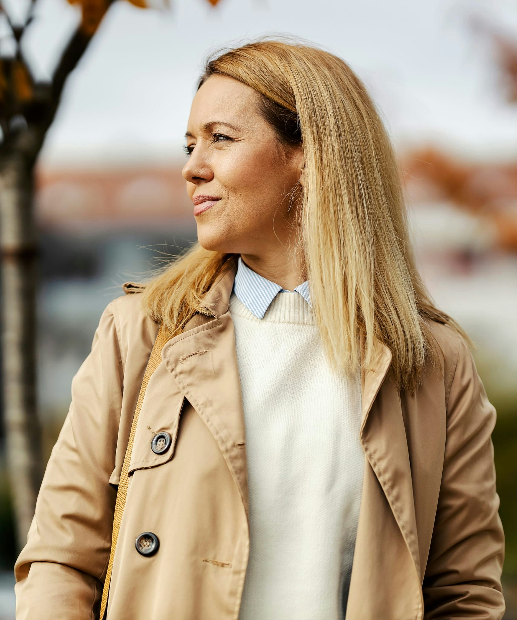 Woman wearing a sweater and coat looking to the side