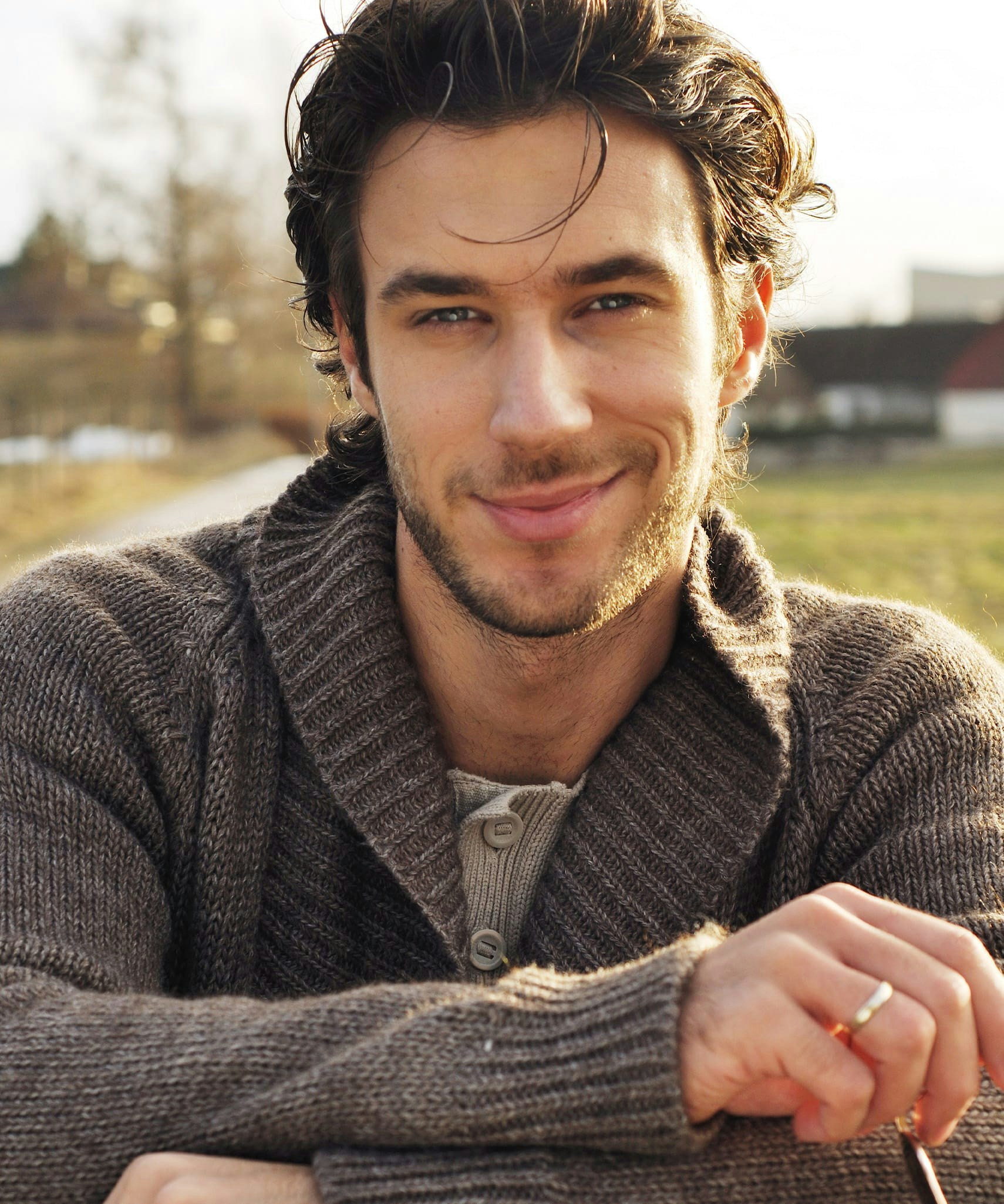 Smiling man in grey sweater.