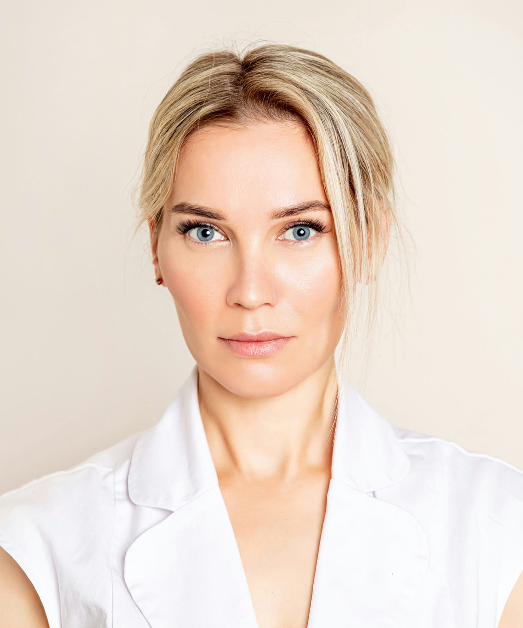 Blonde woman wearing a white blouse.