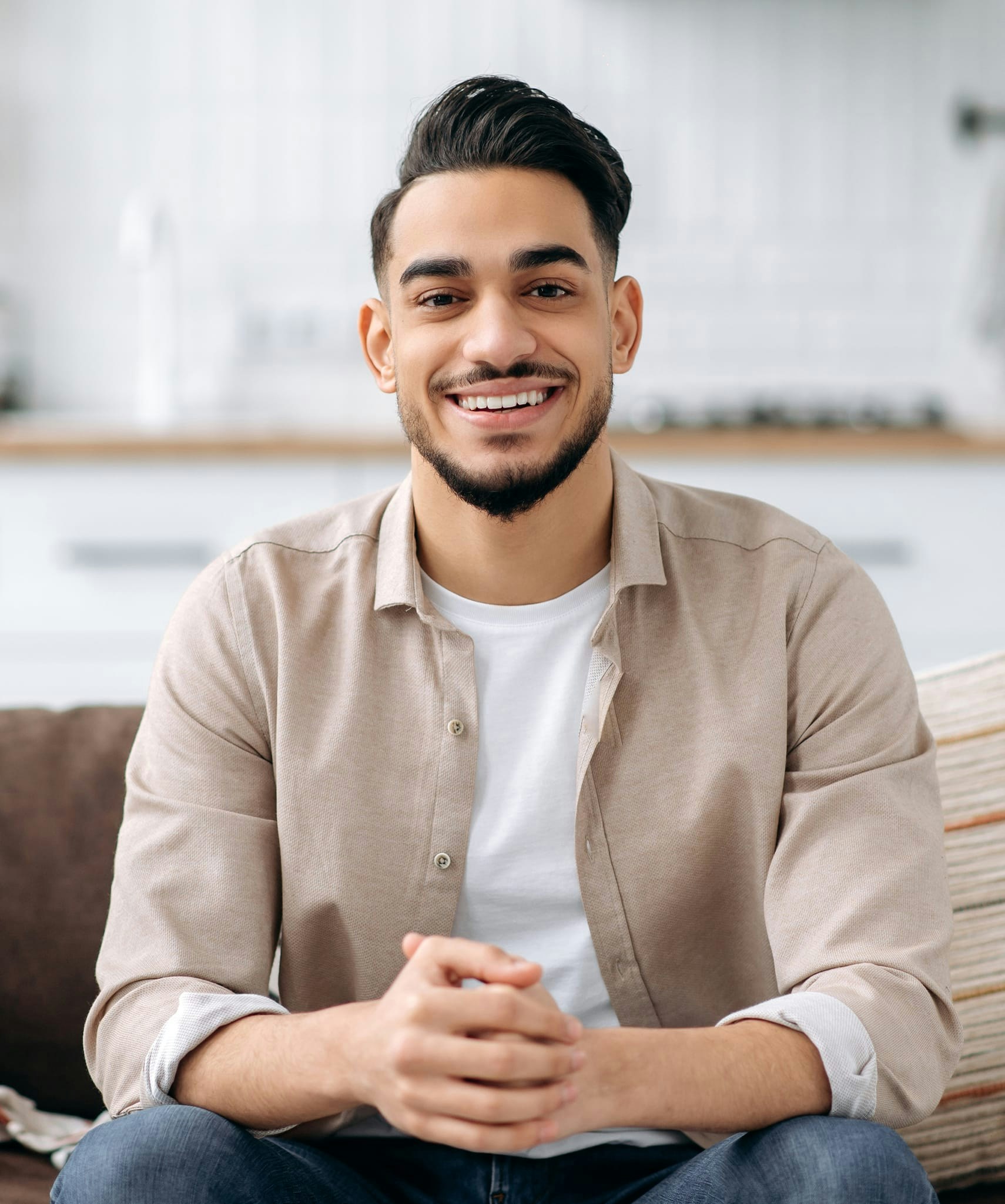 Man in tan button down smiling