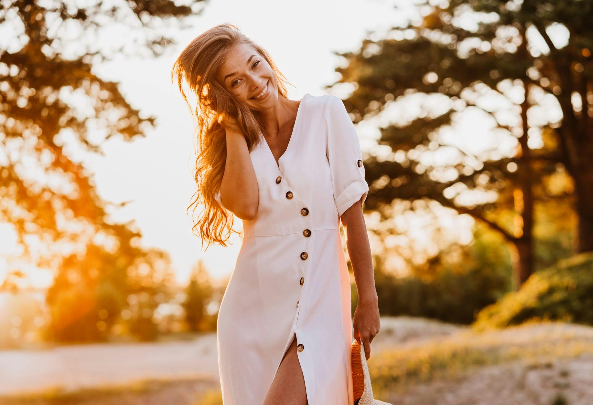 Woman in white button up dress smiling