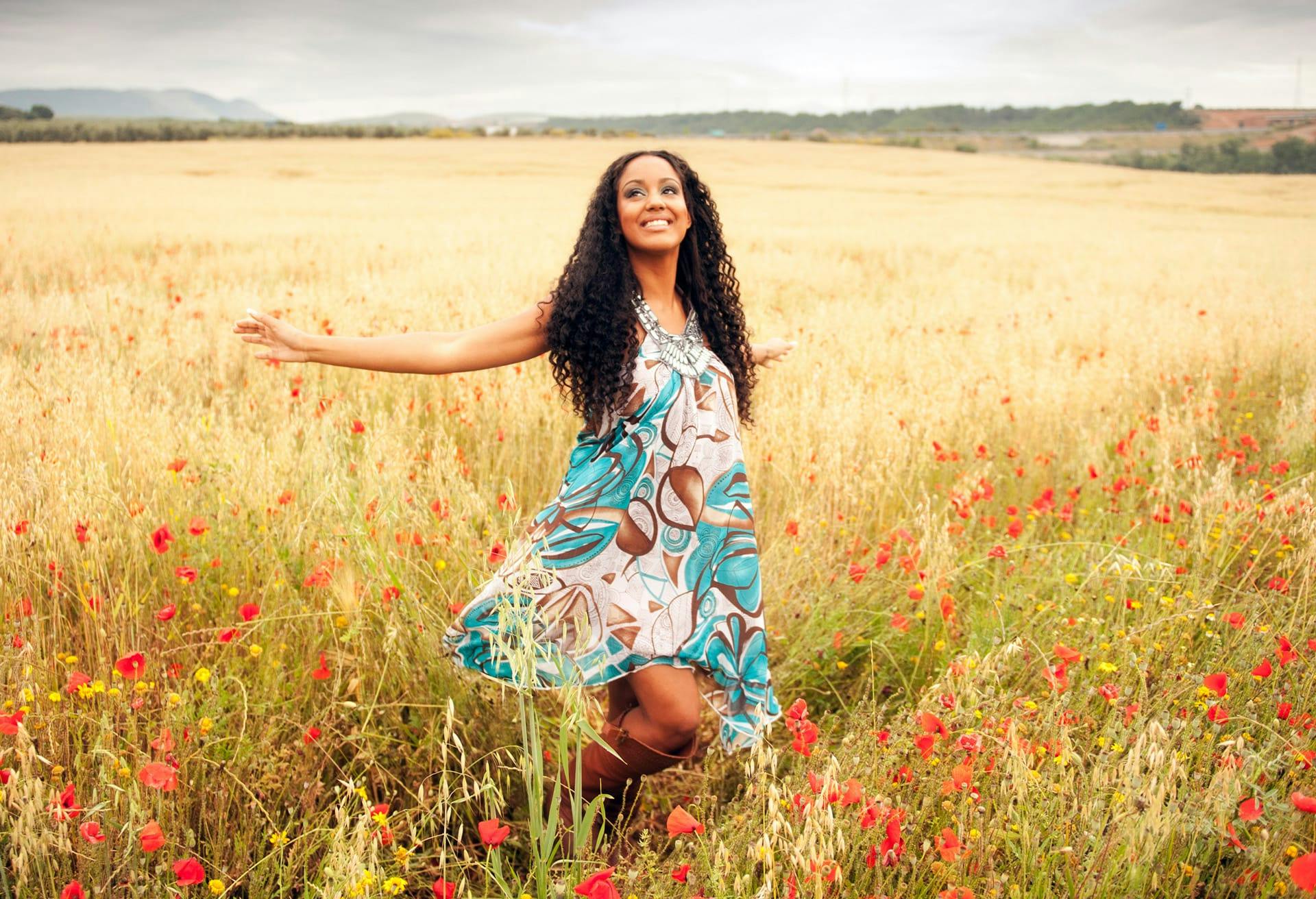 Smiling woman frolicking in field.
