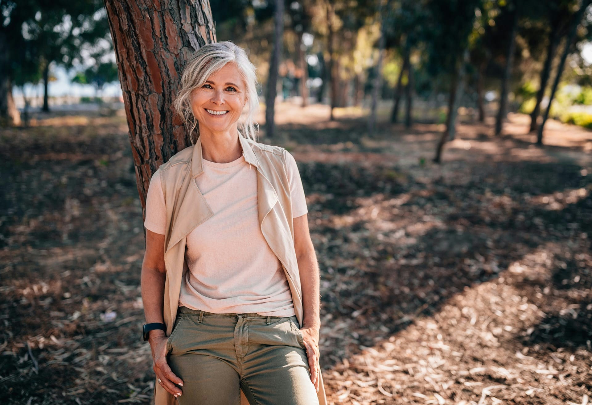 Woman leaning on a tree smiling
