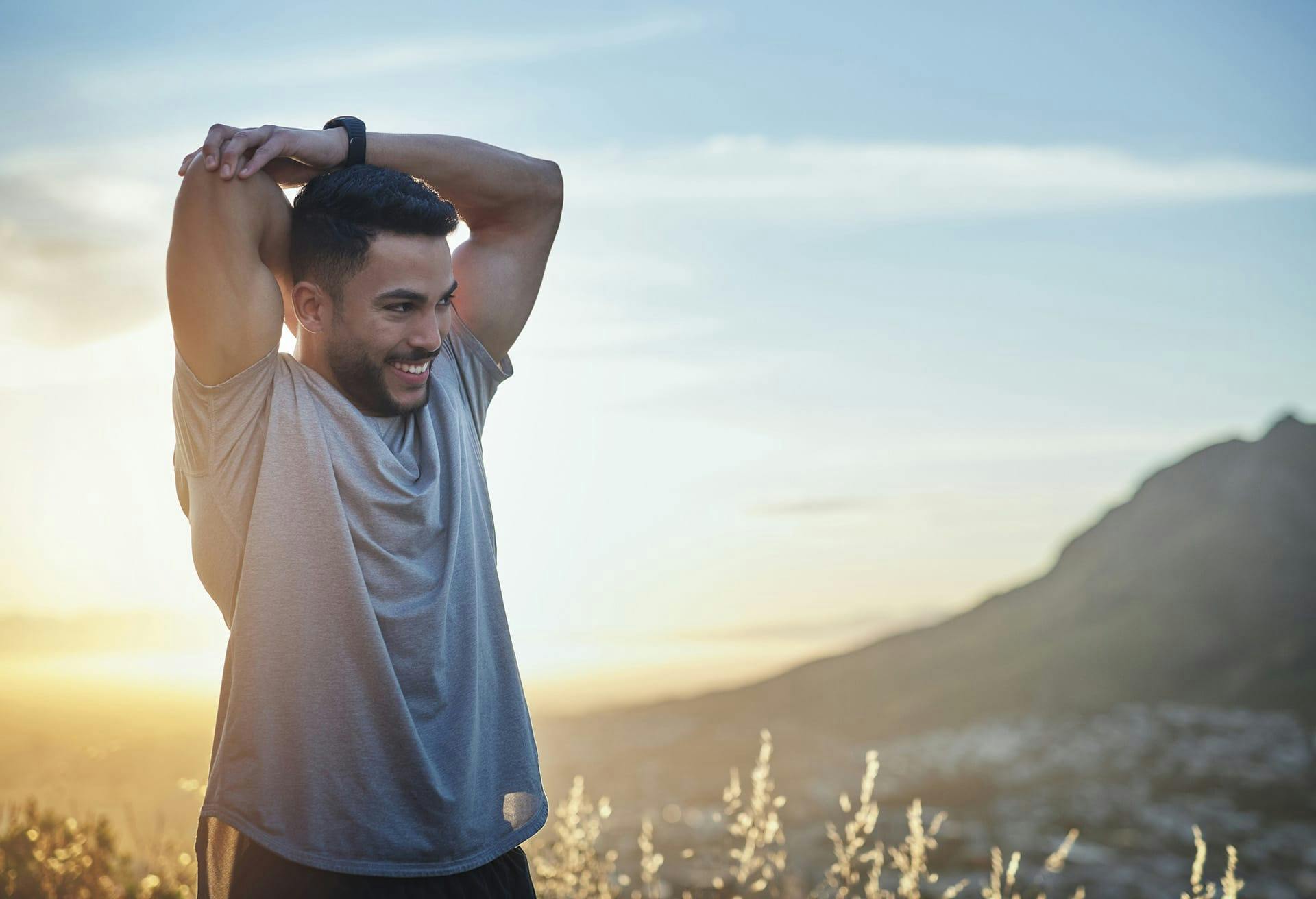 Man in grey shirt stretching