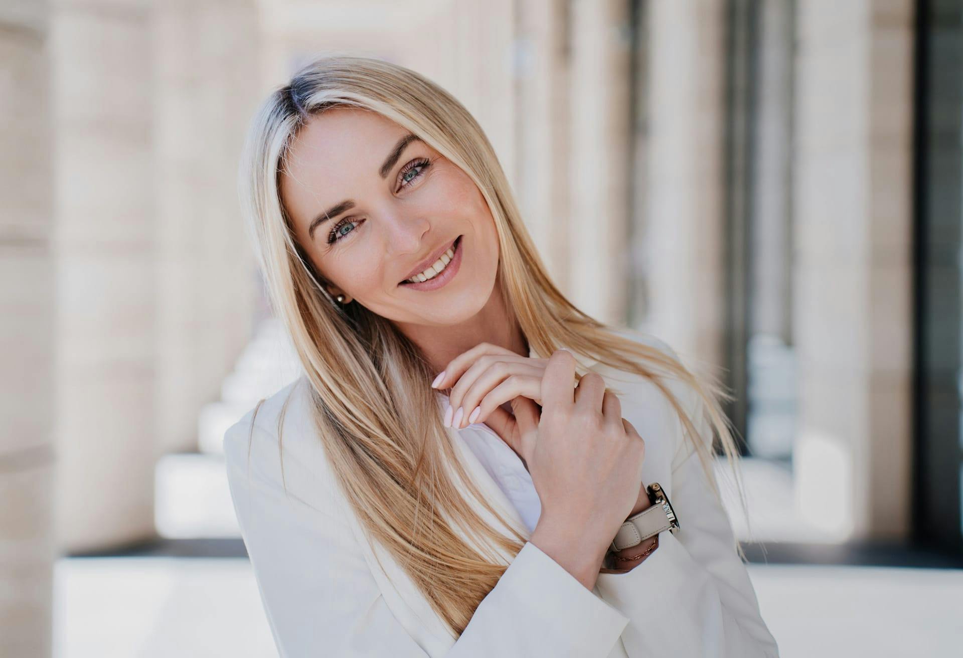 Smiling blonde woman with her head tilted.