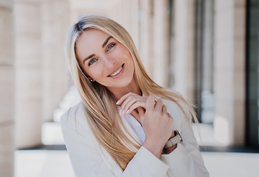 Smiling blonde woman with her head tilted.