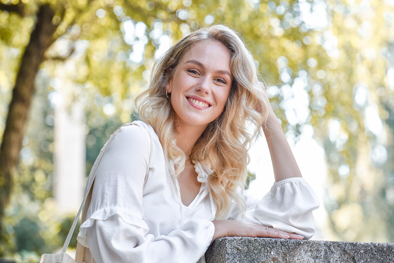 Blonde woman in a white blouse smiling
