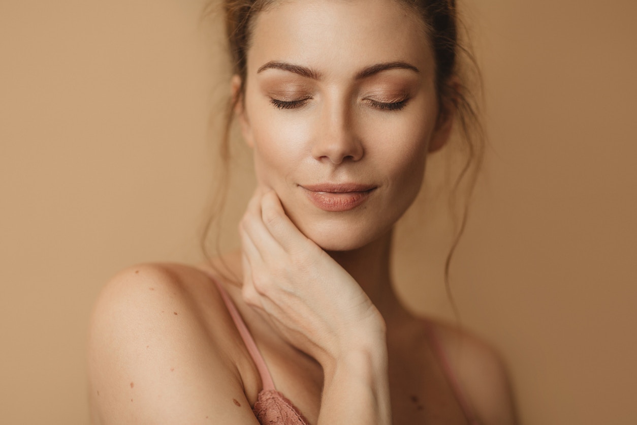 Woman with beautiful smooth skin closes eyes in studio shoot. Her perfect skin emulate the potential results one could achieve with BOTOX in Denver