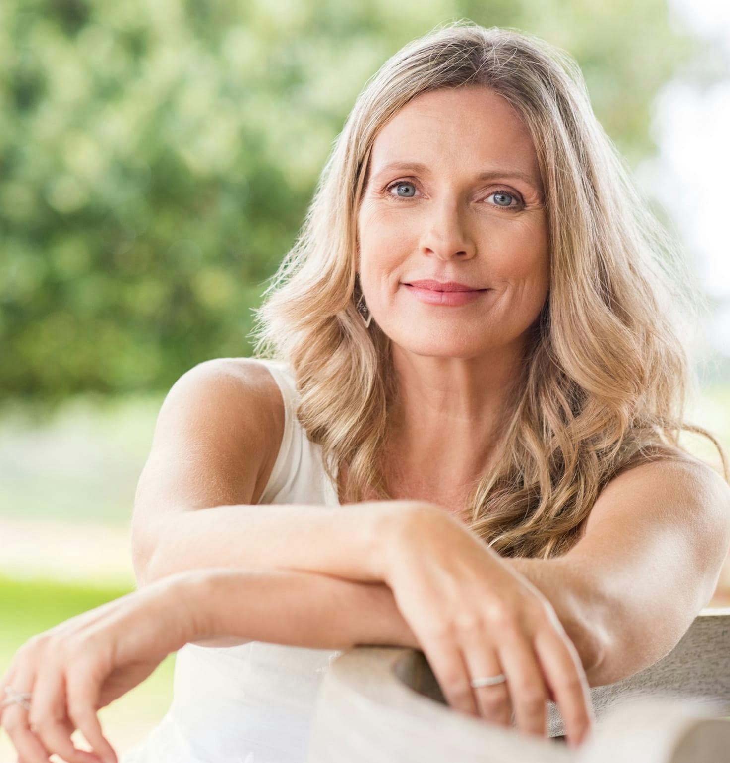 A woman sitting outside crossing her arms