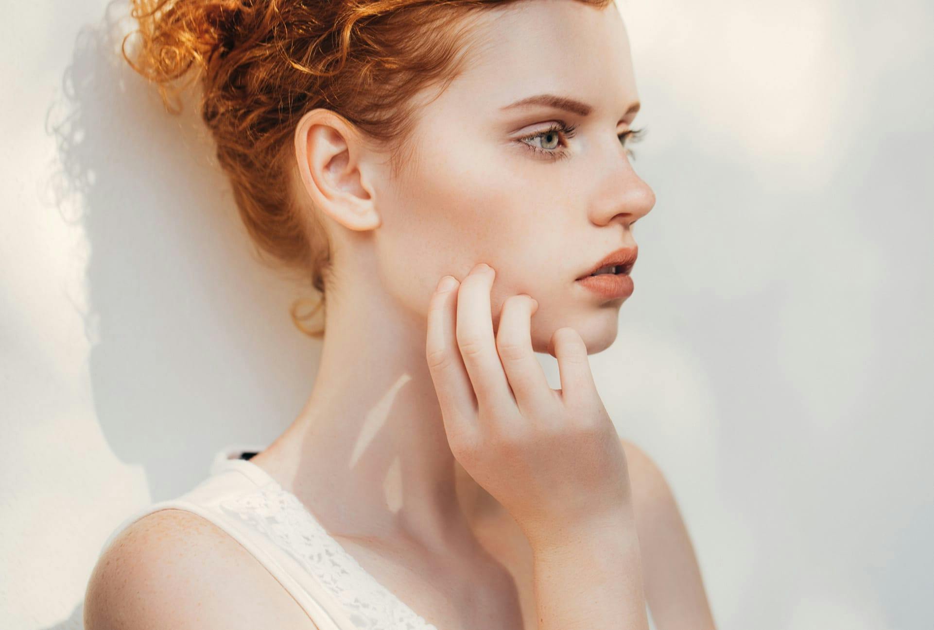 Woman with pale skin and red hair in an updo