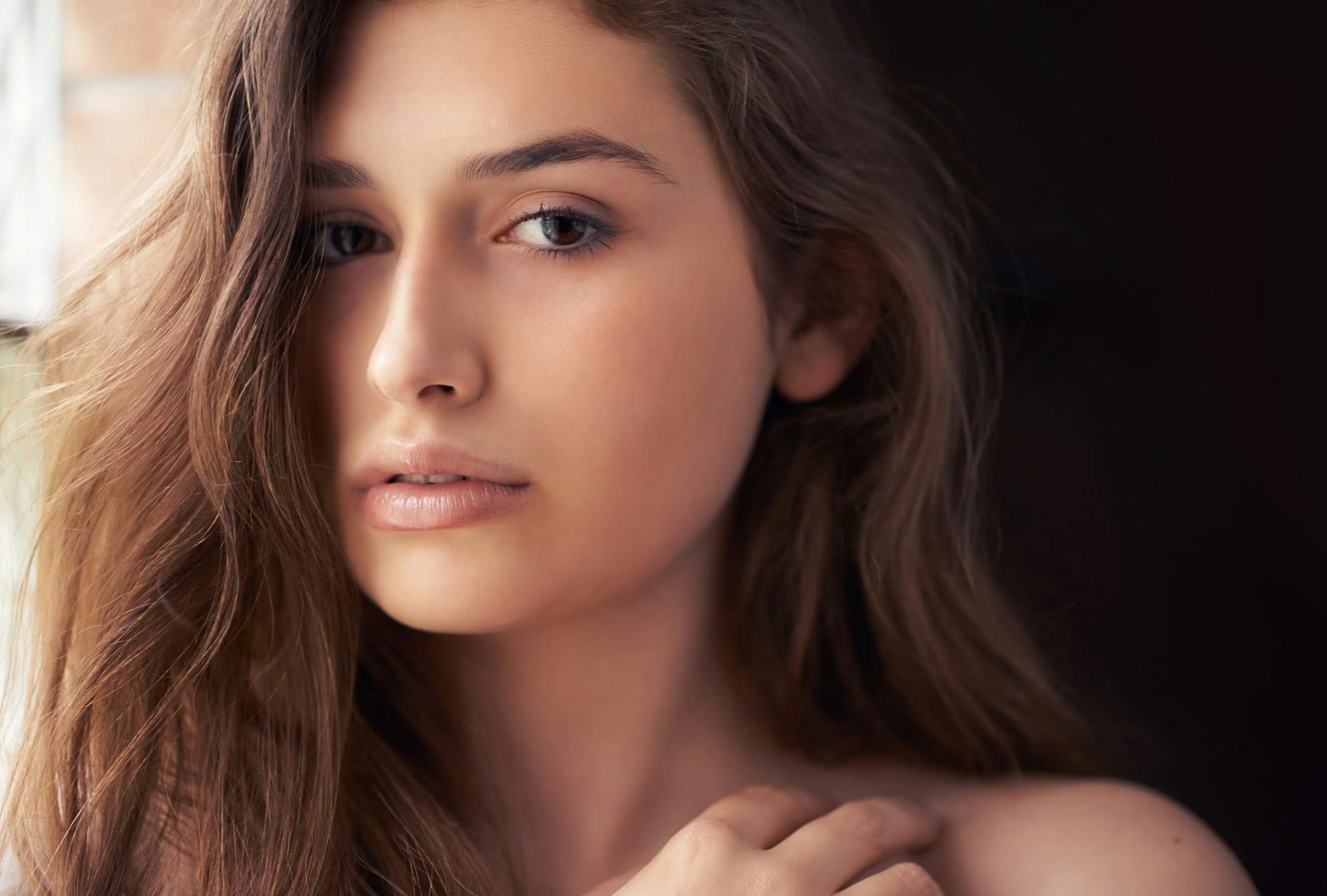 Woman with long brown hair and clear skin