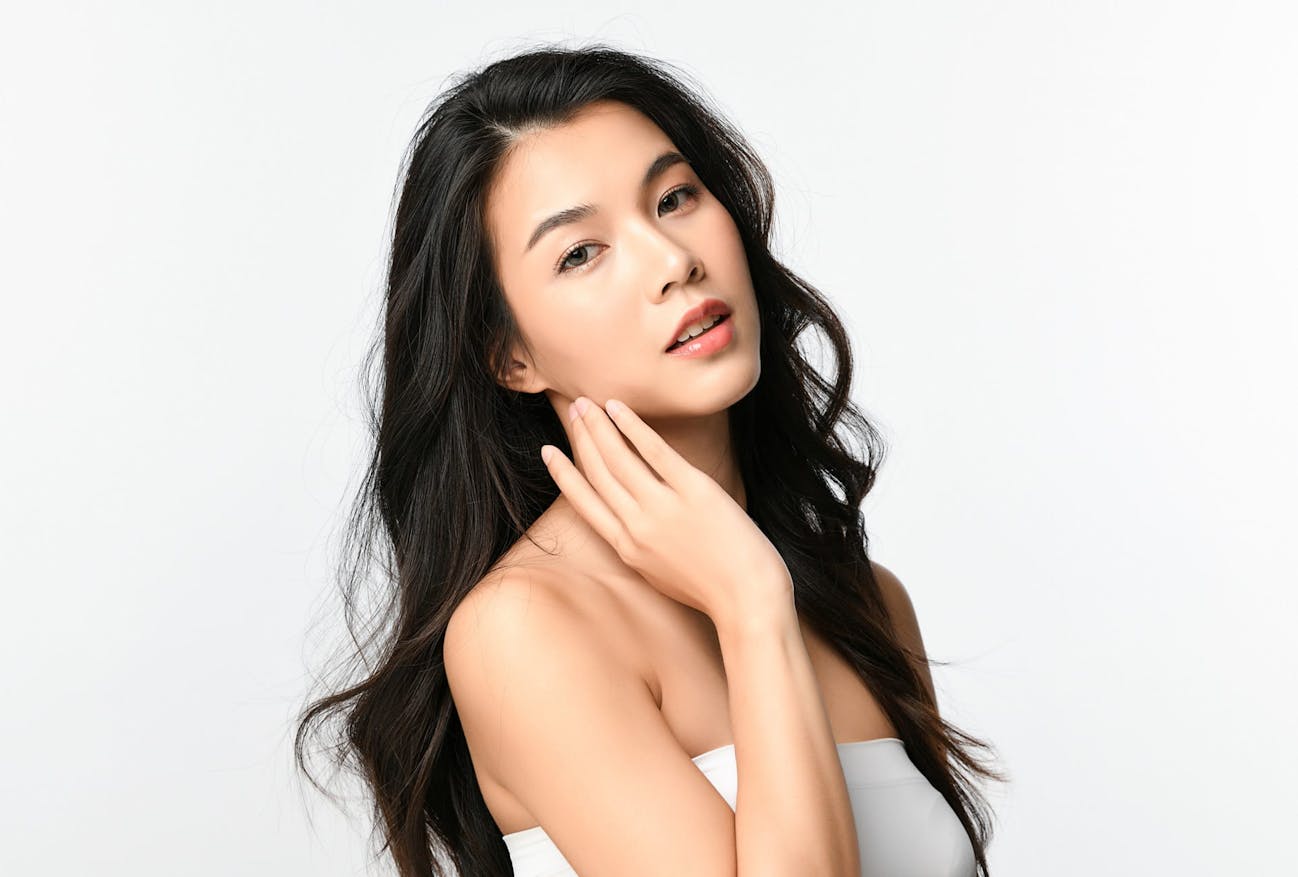 Woman with her head tilted back and her hand to her cheek