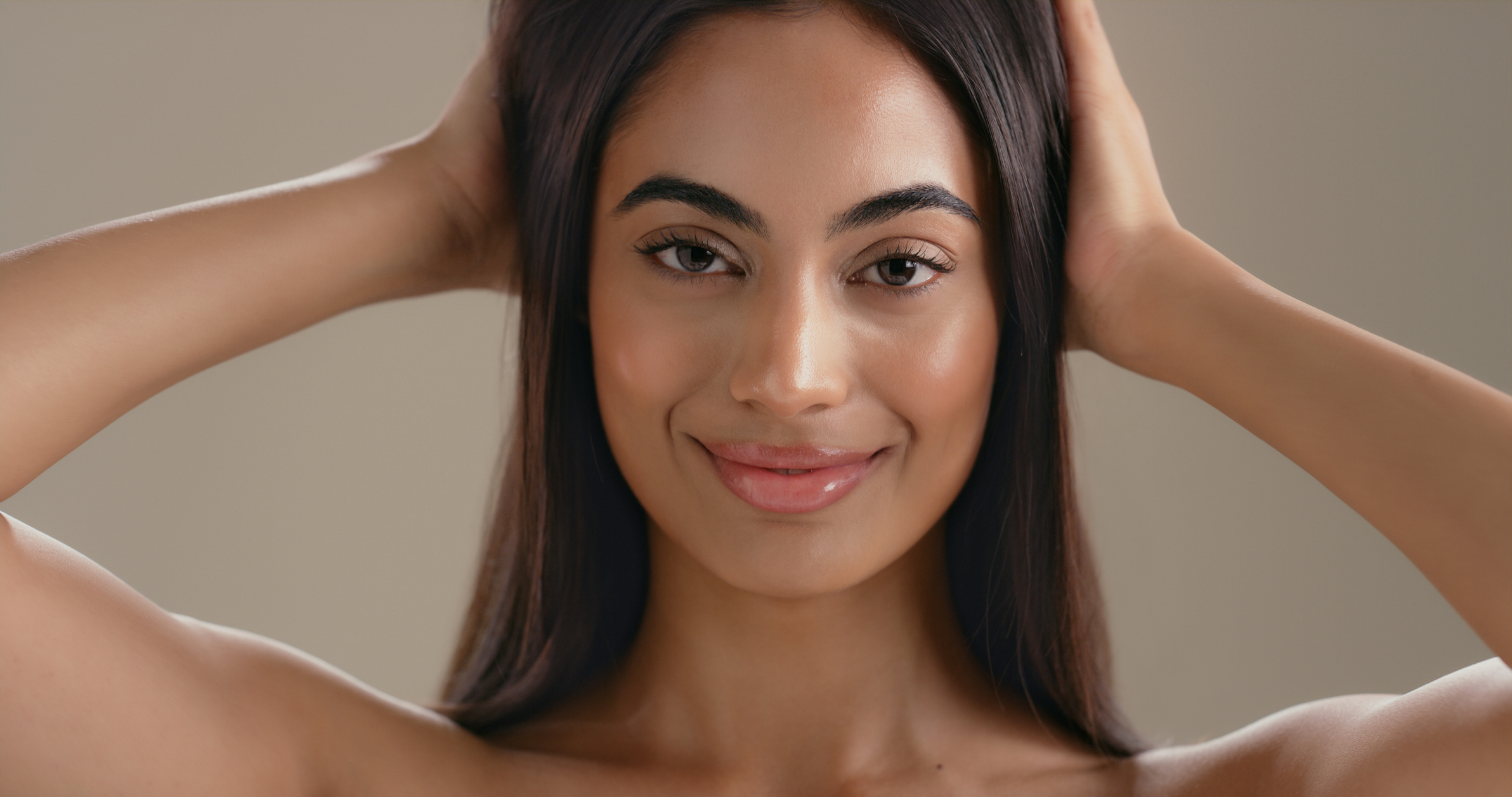 Woman with natural, balanced facial features and smooth skin in soft lighting
