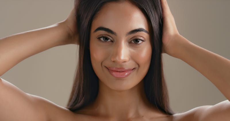 Woman with natural, balanced facial features and smooth skin in soft lighting